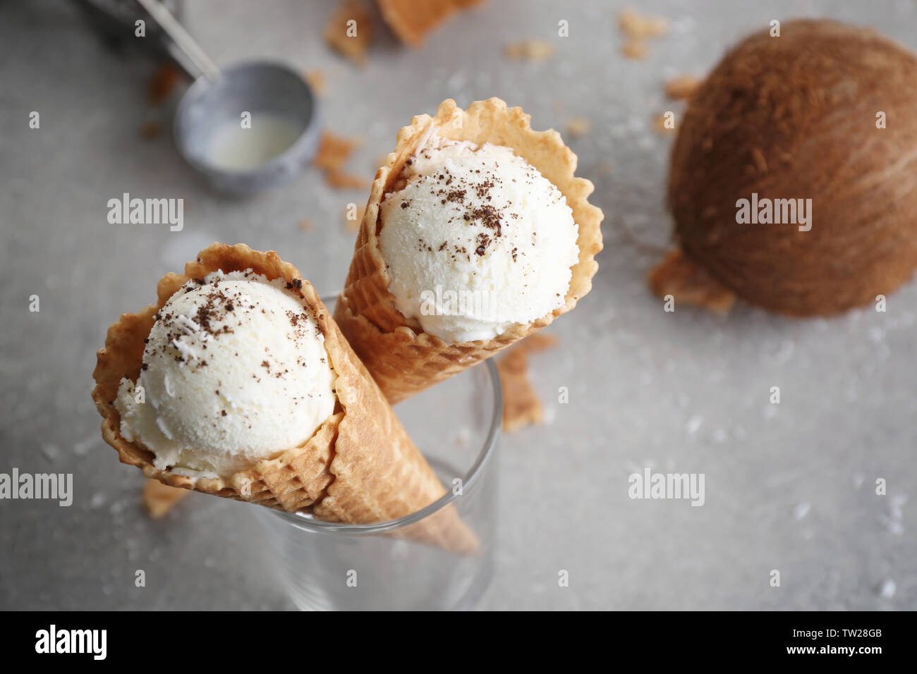 Waffle cones with balls of coconut ice cream in glass on table Stock Photo