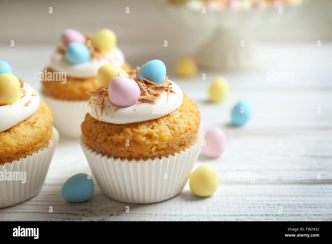 Tasty Easter cupcakes on white wooden table Stock Photo