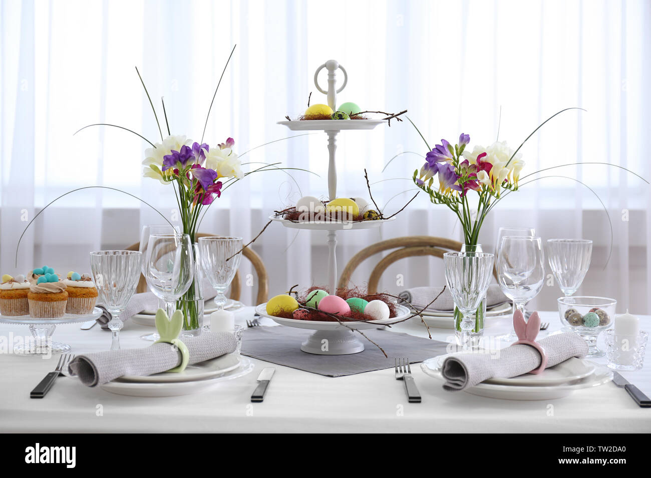 Beautiful Easter table setting in light room Stock Photo
