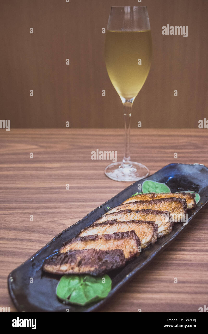 Side dish Kurobuta Hoho Yaki Grilled Iberico Pork Jowl served on spinach leaves Stock Photo Alamy