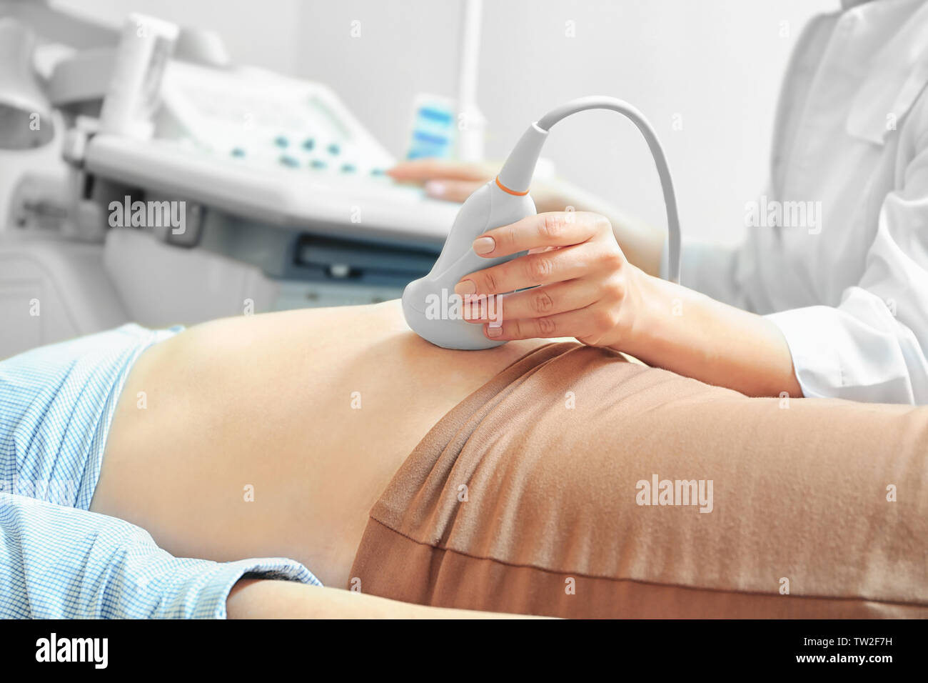 pregnant-woman-undergoing-ultrasound-scan-in-modern-clinic-stock-photo