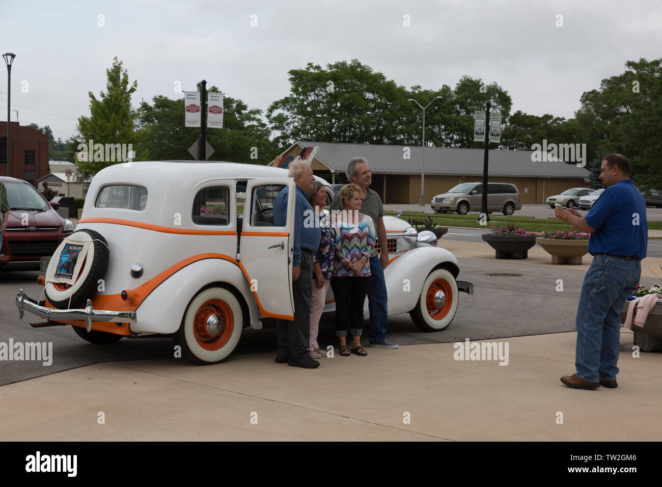A family poses near the white 1935 Auburn 653 sedan they rode in during the Auburn Cord Duesenberg Museum's Father's Day Classic Car Cruise in Indiana. Stock Photo
