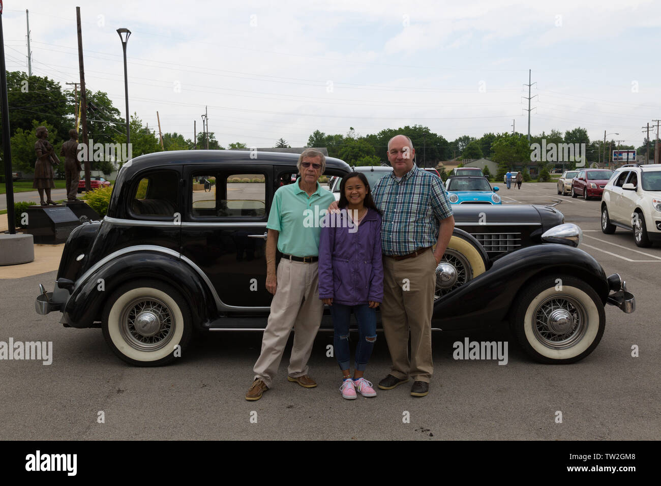 A family poses near the black 1935 Auburn 851 sedan they rode in during the Auburn Cord Duesenberg Museum's Father's Day Classic Car Cruise in Indiana. Stock Photo