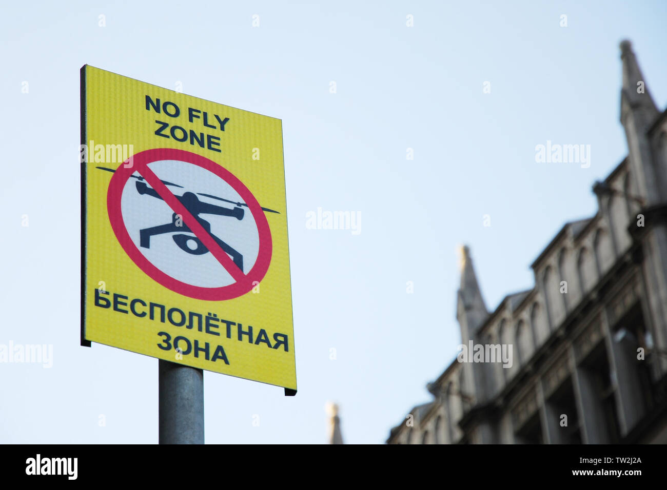 Sign prohibiting drone flying with inscription 'No fly zone' in English and Russian languages Stock Photo