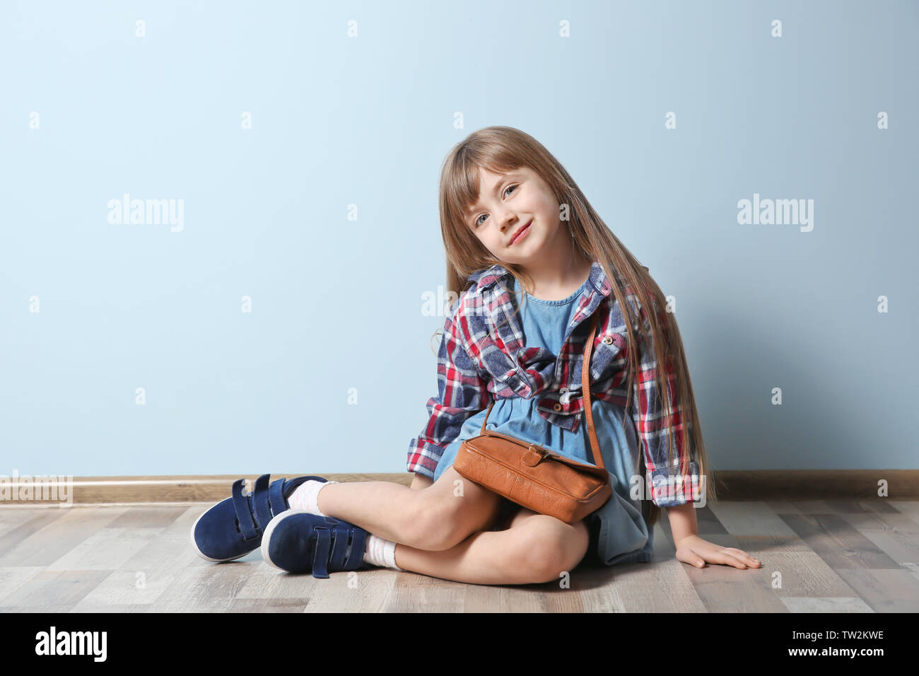 Cute little girl sitting on floor. Fashion concept Stock Photo - Alamy