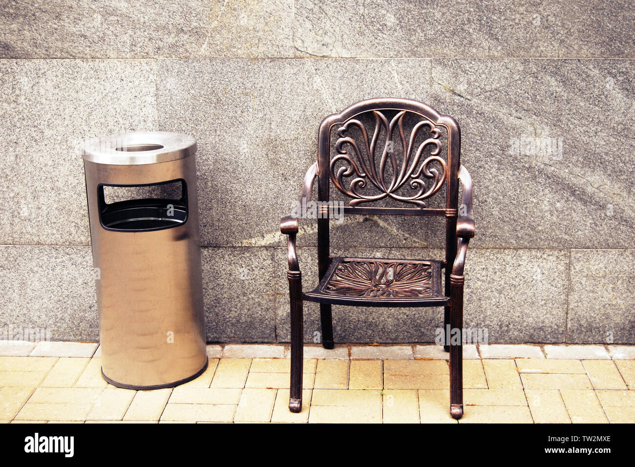 Smoking area metal chair and outdoor trash can with ashtray against gray marble wall Stock Photo Alamy