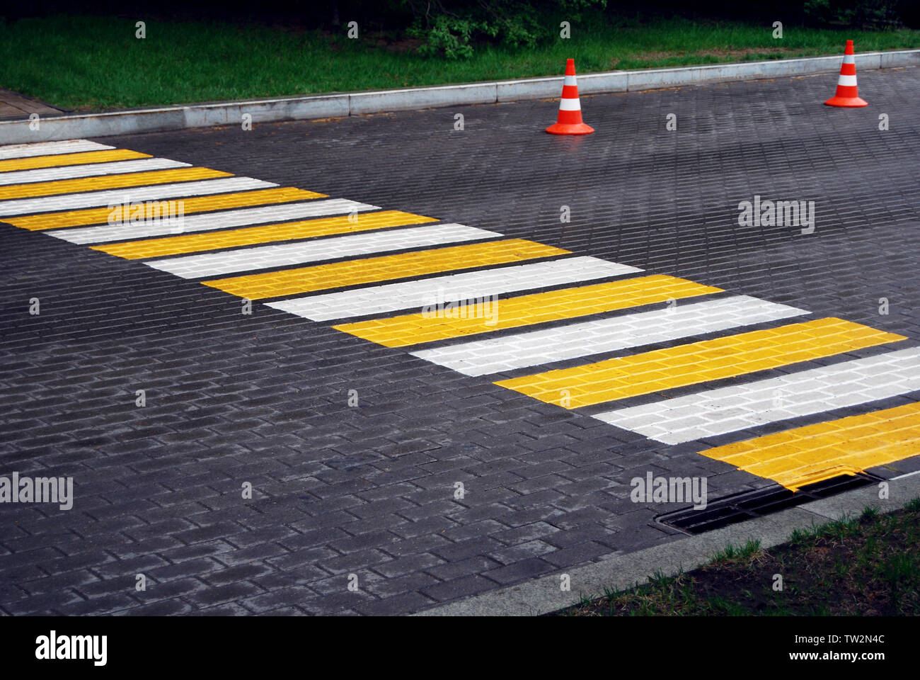 Pedestrian crossing and traffic cones on a paved road on rainy day Stock Photo