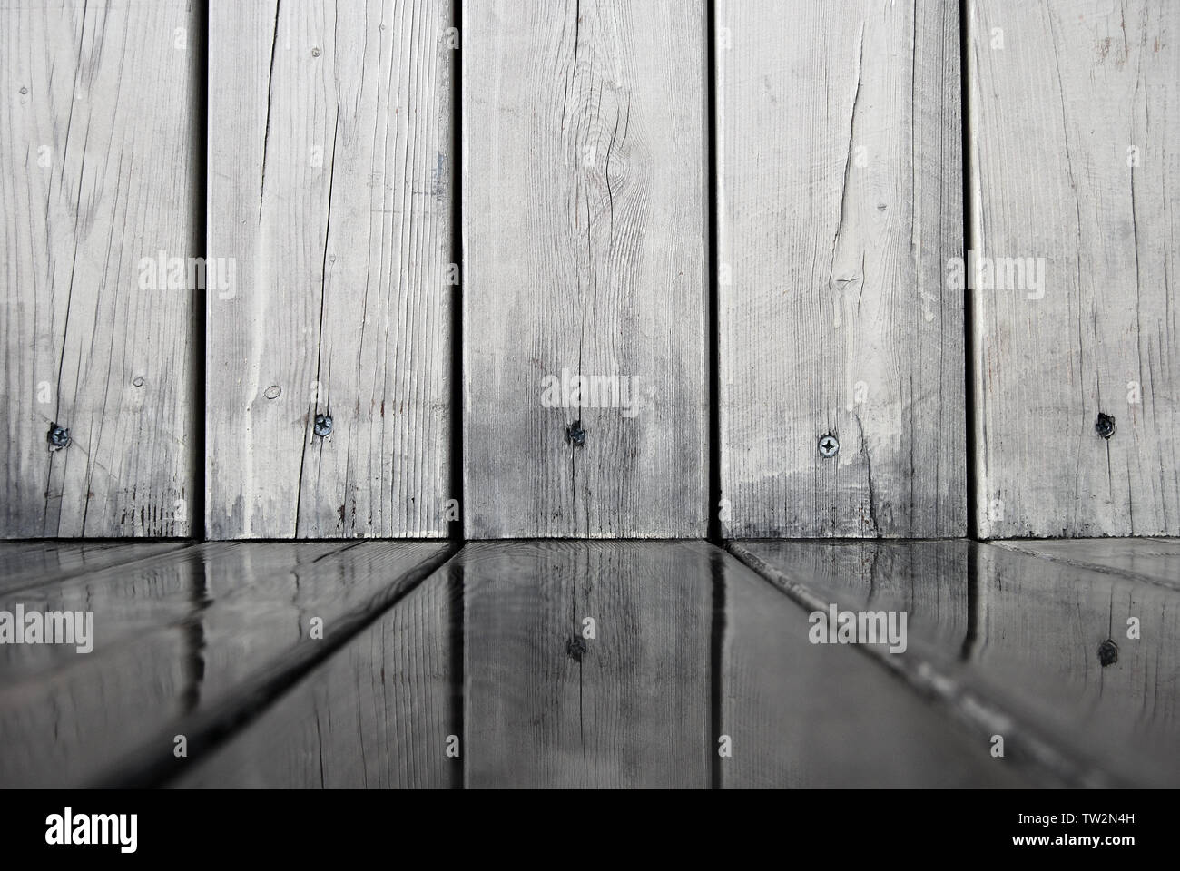 Wooden wall is reflected in water on of wooden flooring boards, abstract background in gray tones Stock Photo