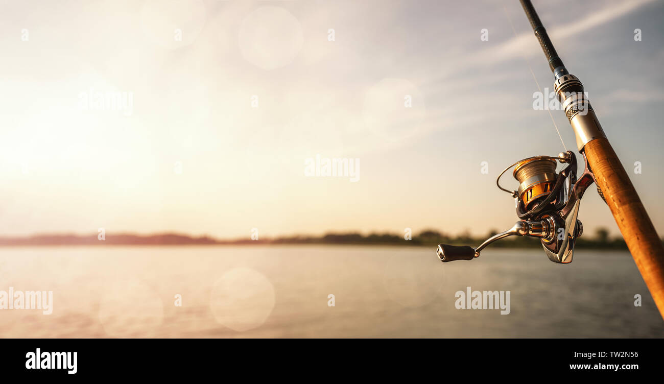 Close up of a fishing rod during the sunset with copy space Stock Photo