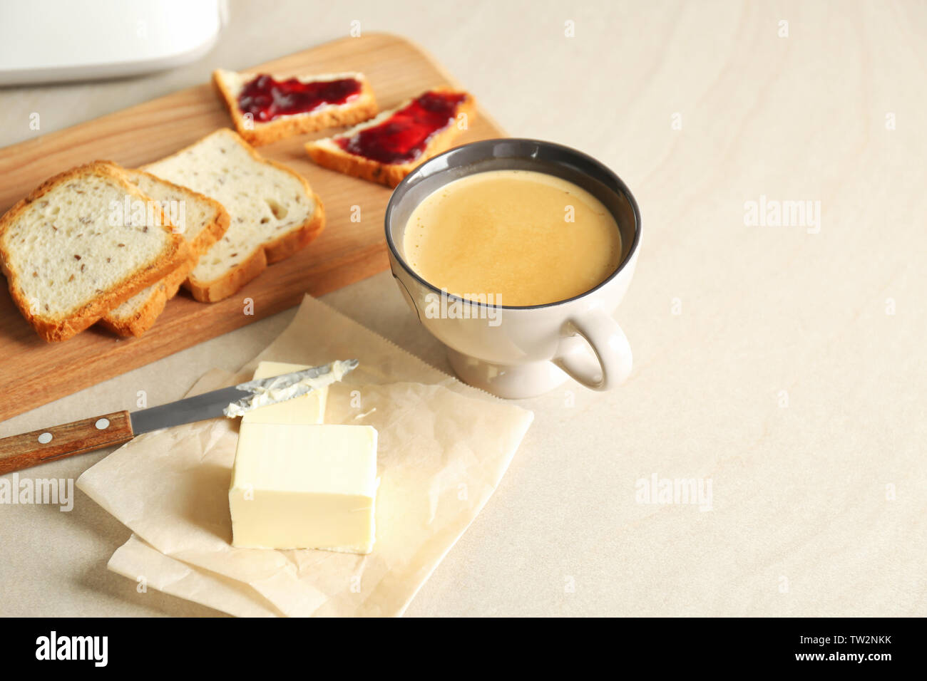 Composition with butter coffee and toasts on kitchen table Stock Photo