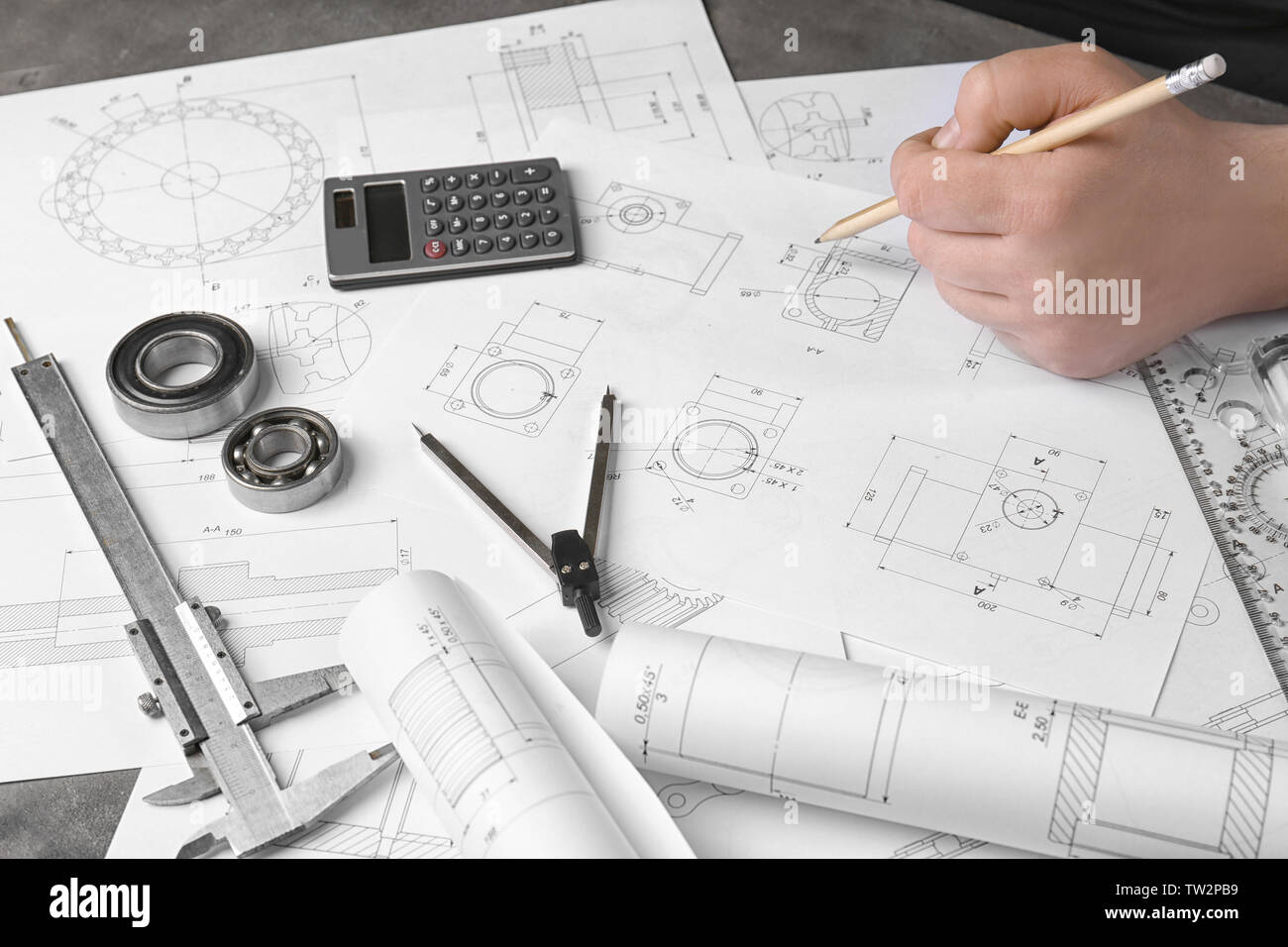 Engineer working with part blueprints on workplace Stock Photo - Alamy