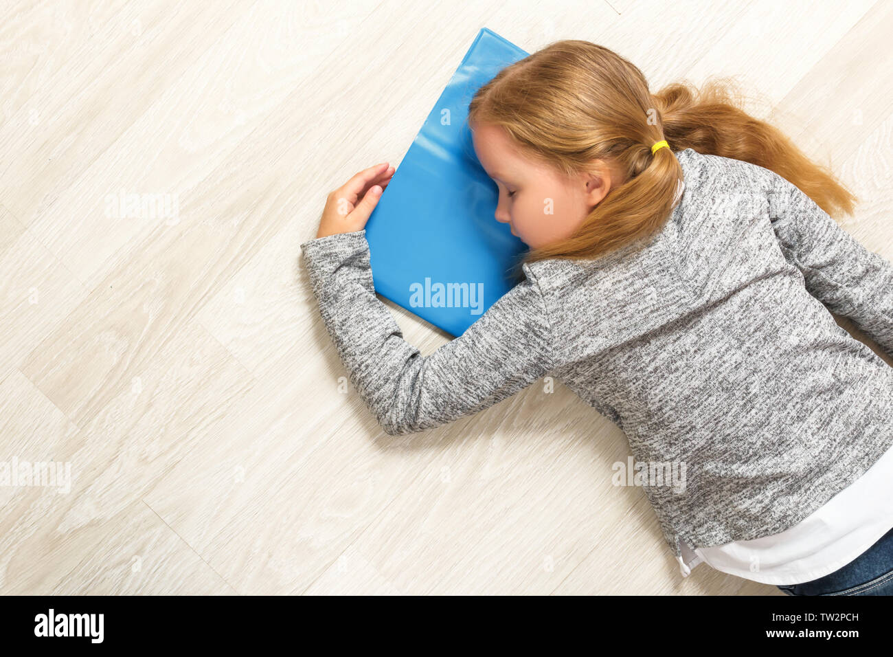The little girl lies and sleeps on the floor. The child fell asleep