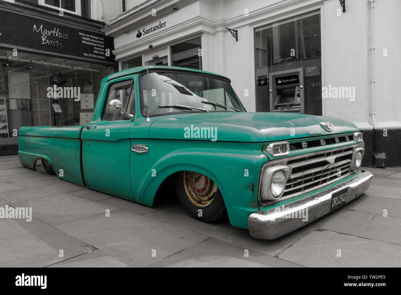 Lowered Ford pick up truck green colour color pop black and white conversion  extreme lowered body on public town centre vehicle event show Horsham UK Stock Photo