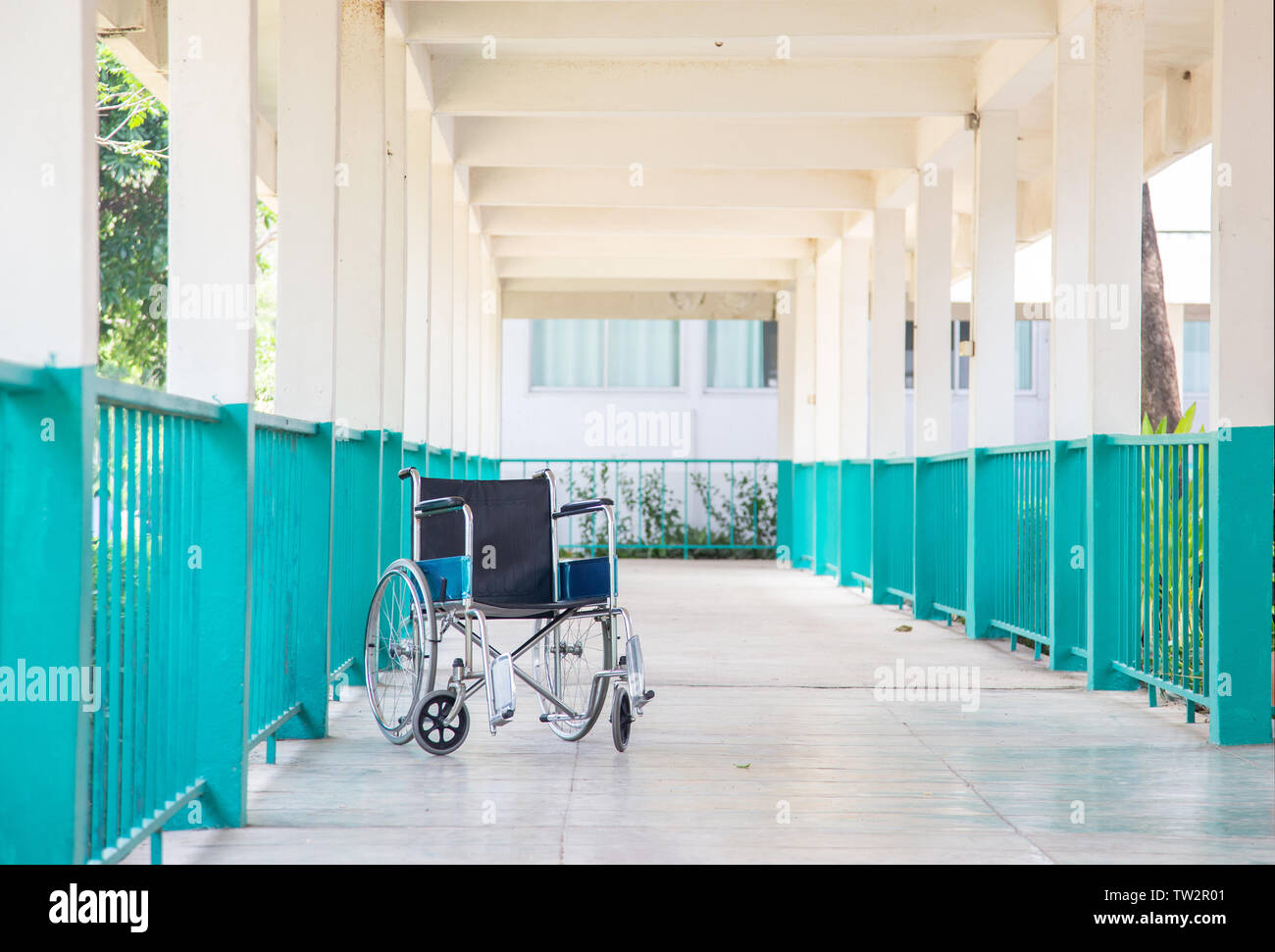 empty patient wheelchair on walking way at hospital Stock Photo