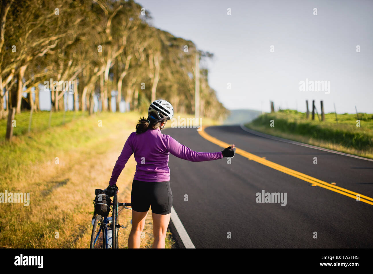 Woman with her bike trying to catch a ride Stock Photo - Alamy