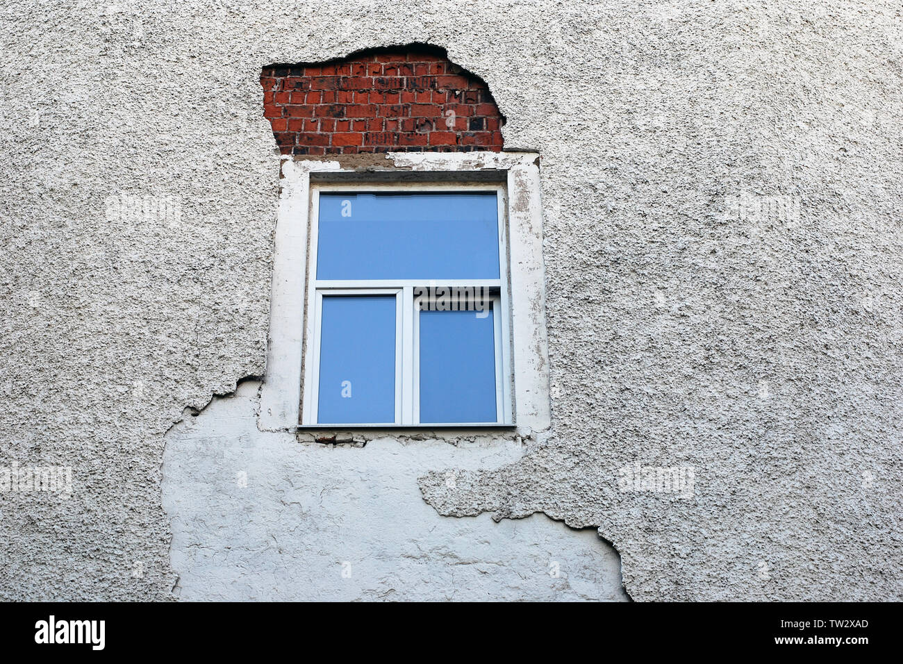 Old building wall with fallen off facing around the newly installed ...