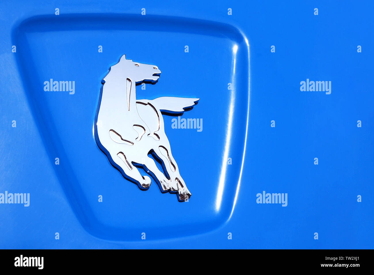 Moscow 06/06/2019 Kamaz logo close up, shining running silver horse on blue background, nameplate on city electric bus. Stock Photo