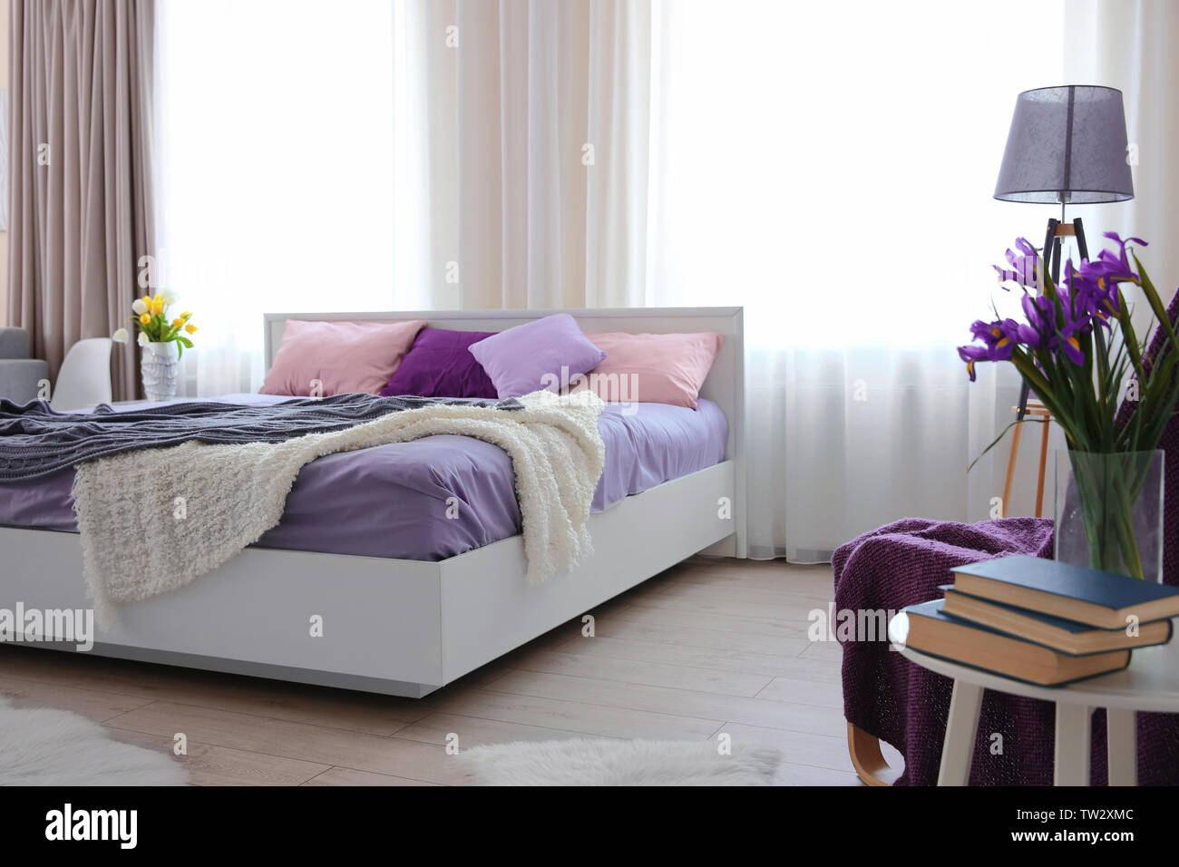 Interior of light modern bedroom with lilac bedding Stock Photo - Alamy, image size:1300x956