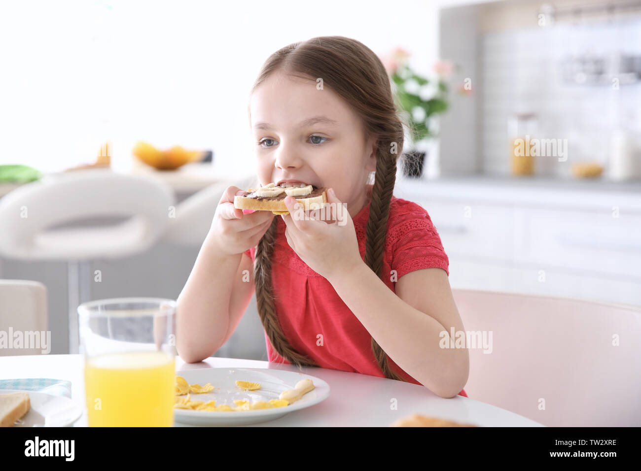 Breakfast Little Cute little girl having breakfast at home Stock Photo - Alamy