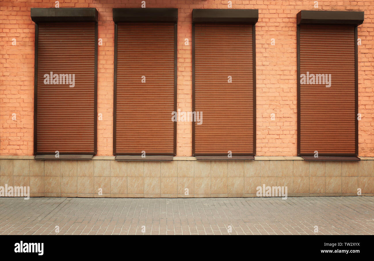 Windows with closed roller blinds in wall Stock Photo