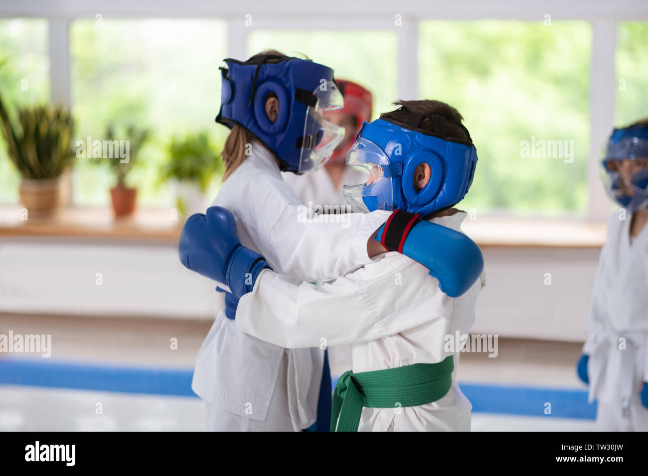 Practicing fight. Boy and girl wearing protective helmets practicing fight together Stock Photo