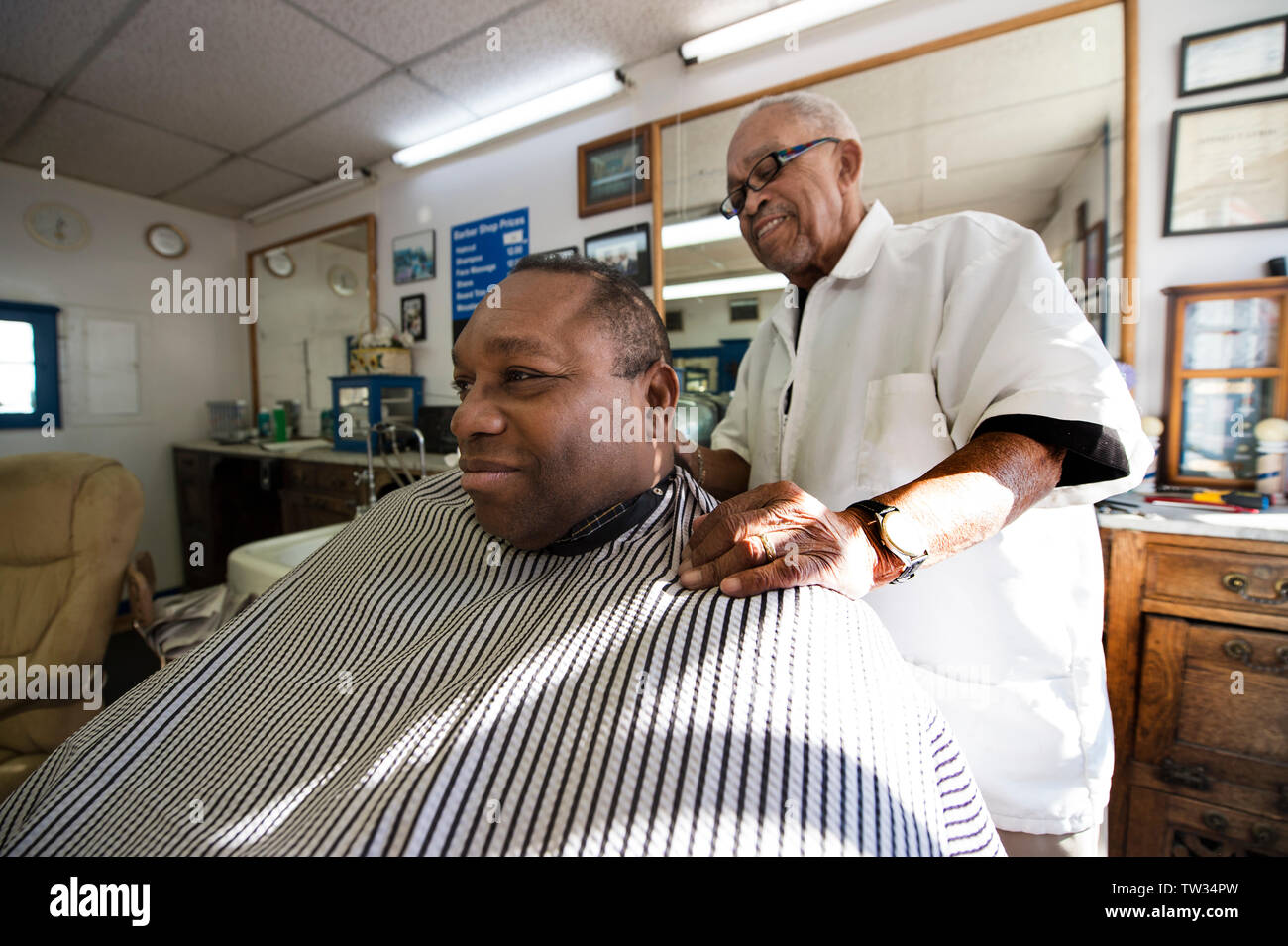 UNITED STATES - November 16. 2015: Nelson Lassiter cuts the hair of Ken Hills from Sterling Virginia at his barber shop in downtown Leesburg Virginia. Stock Photo