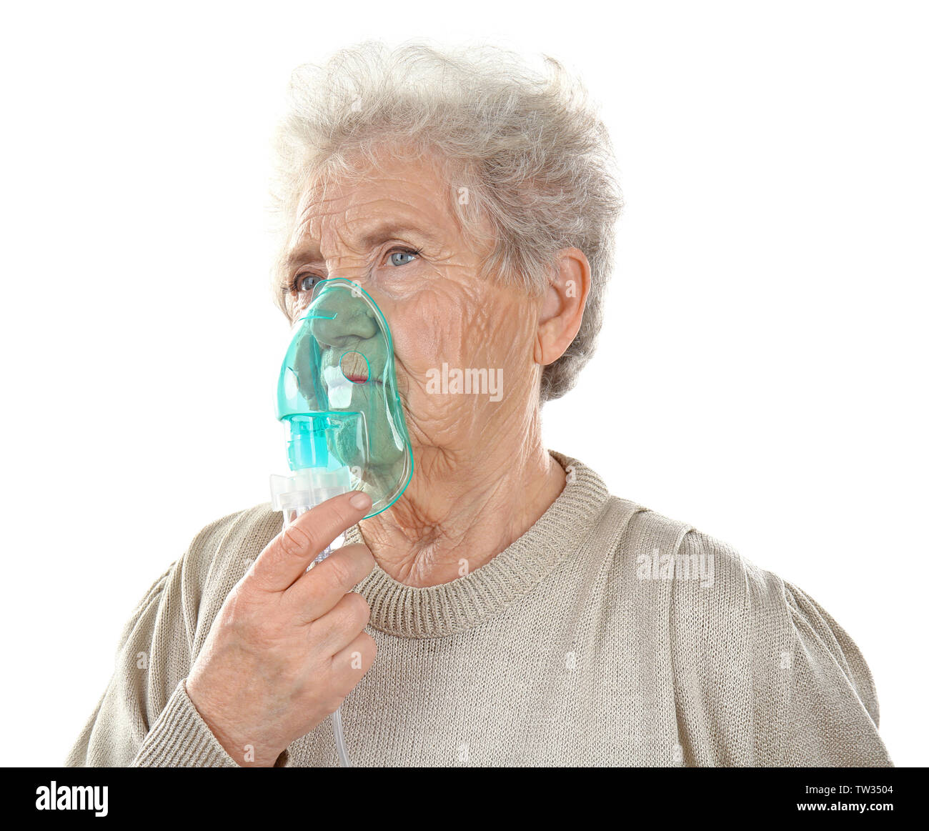 Elderly woman using asthma machine on white background Stock Photo