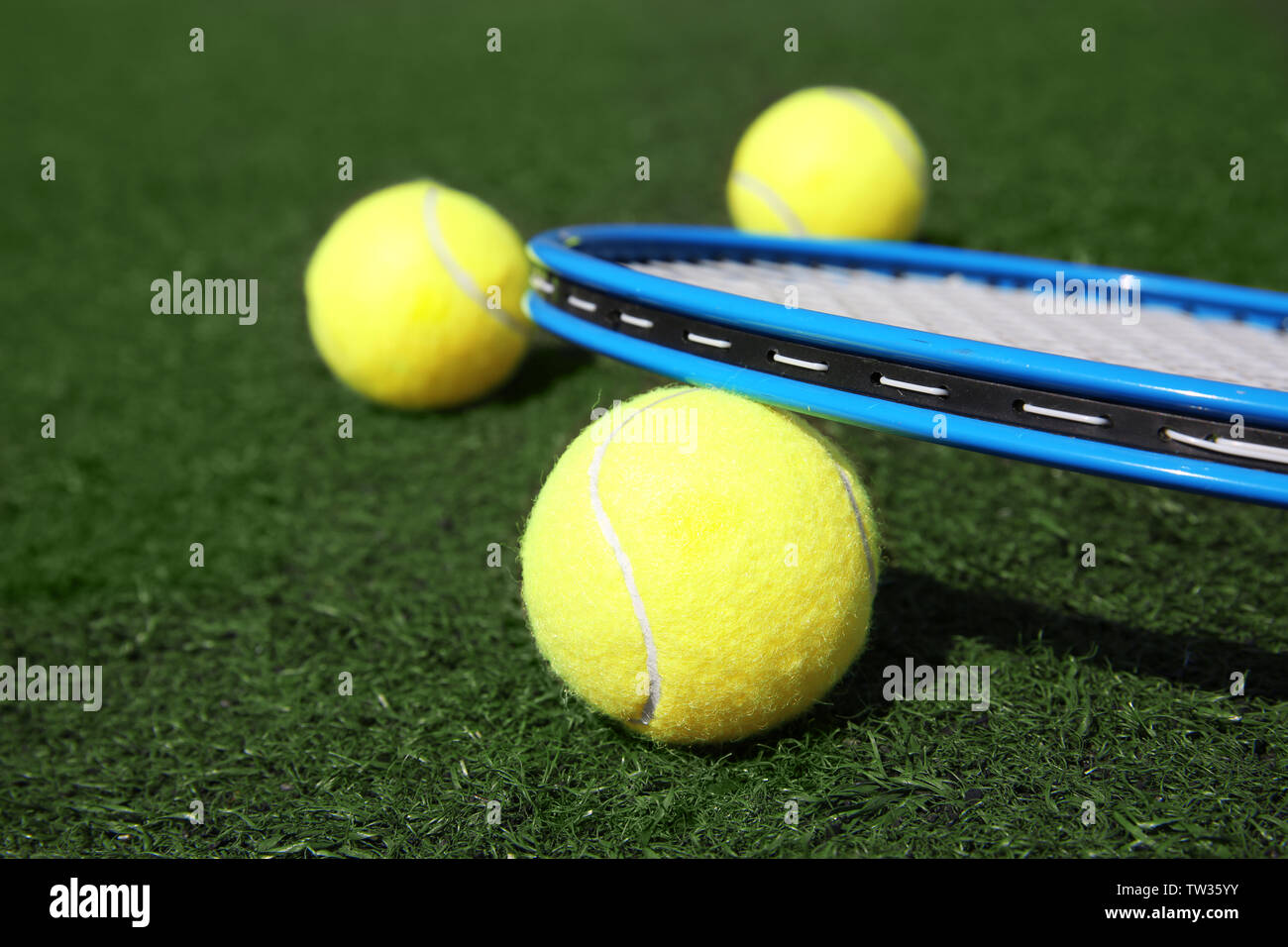 Tennis ball and racket on fresh green grass outdoors Stock Photo - Alamy