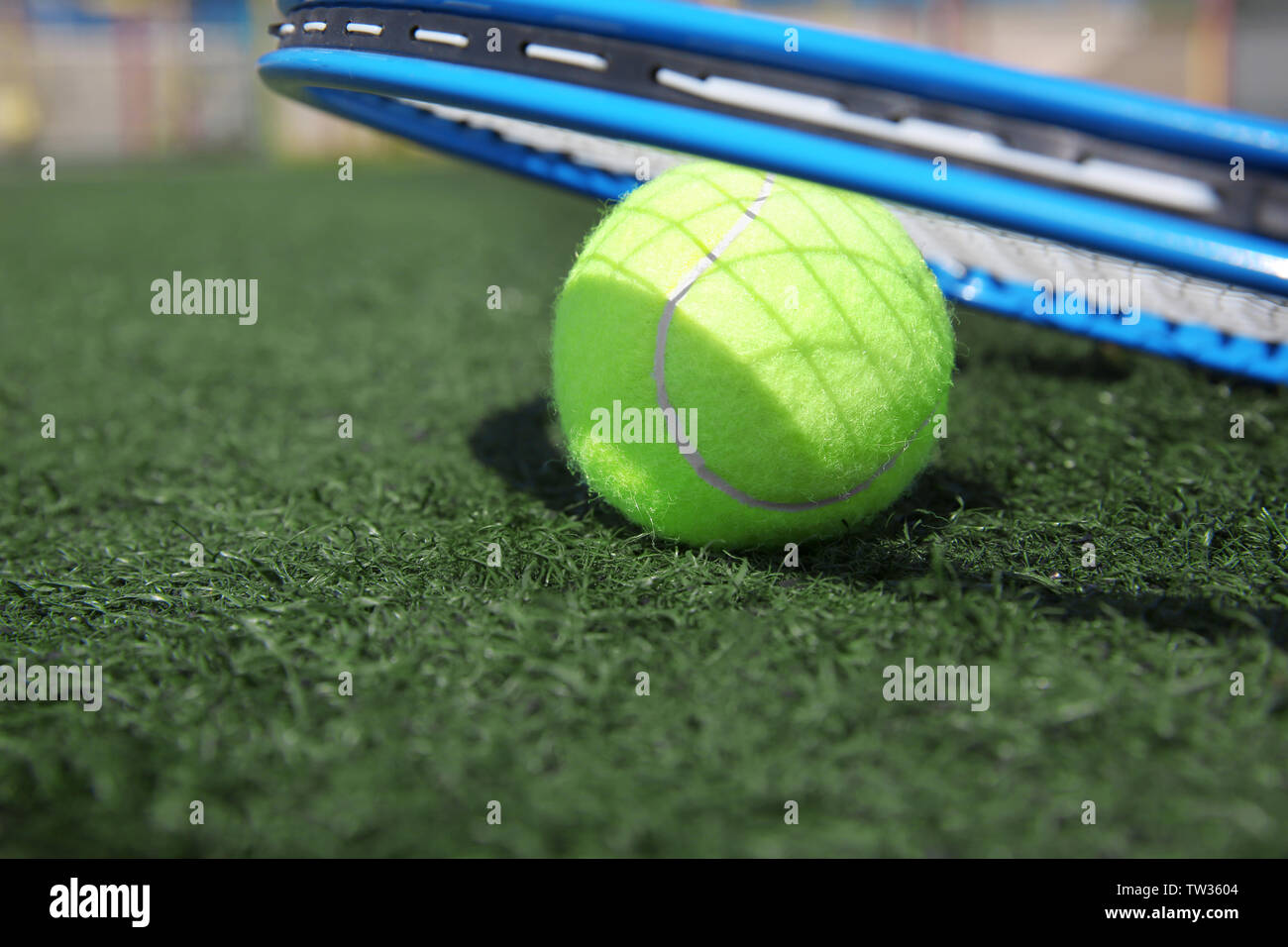 Tennis ball and racket on fresh green grass outdoors Stock Photo - Alamy