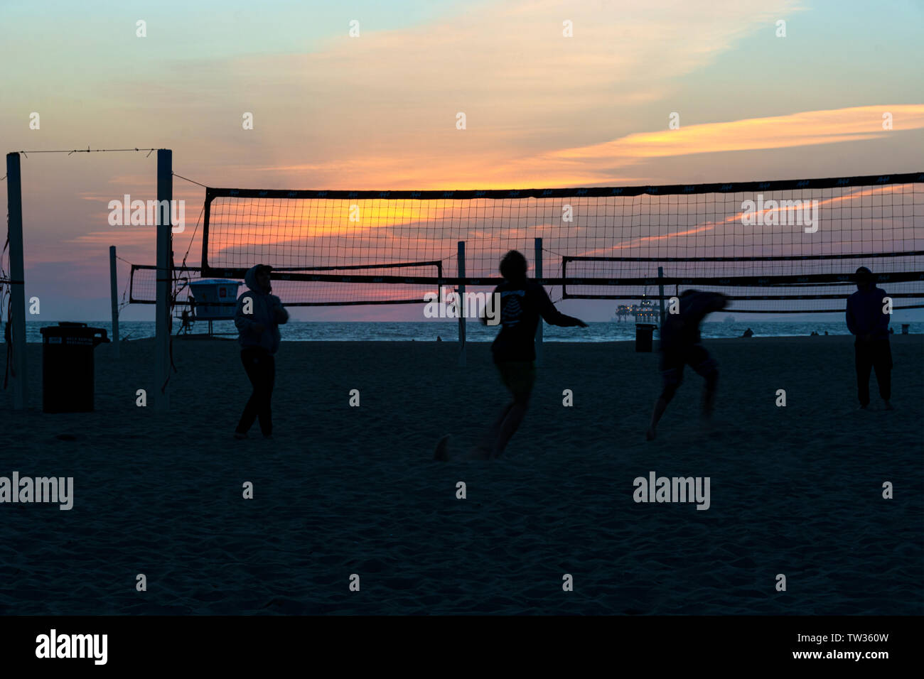 Huntington Beach, CA / March 25, 2019: Silhouettes of volleyball players on the beach at sunset in Huntington Beach, California. Stock Photo
