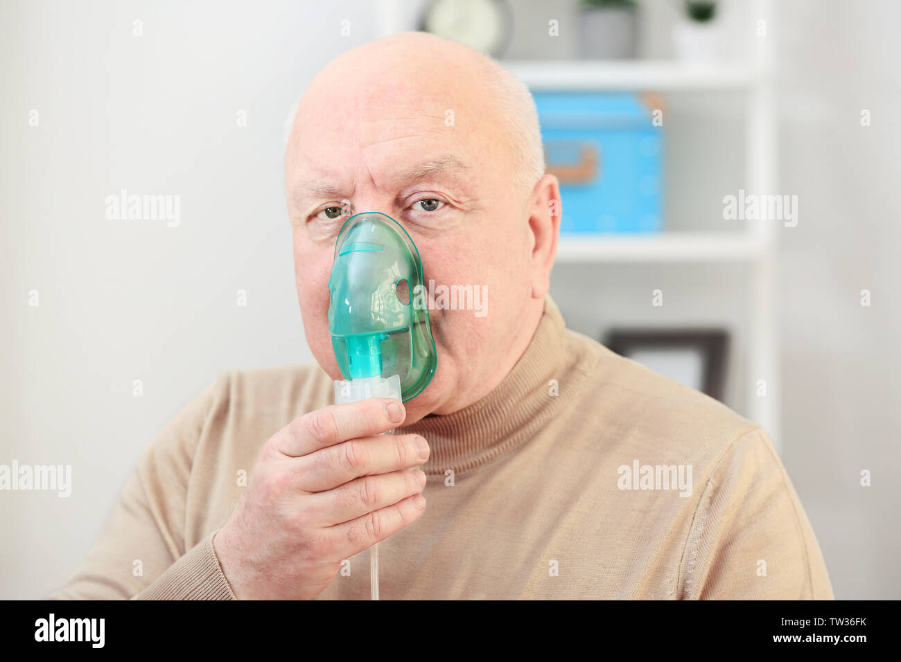Senior man using asthma machine at home Stock Photo