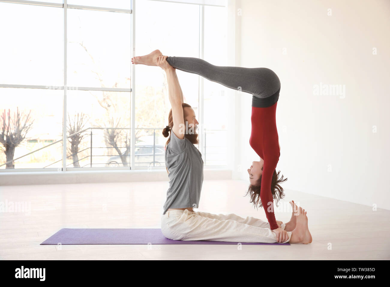 Young couple practicing yoga indoors Stock Photo