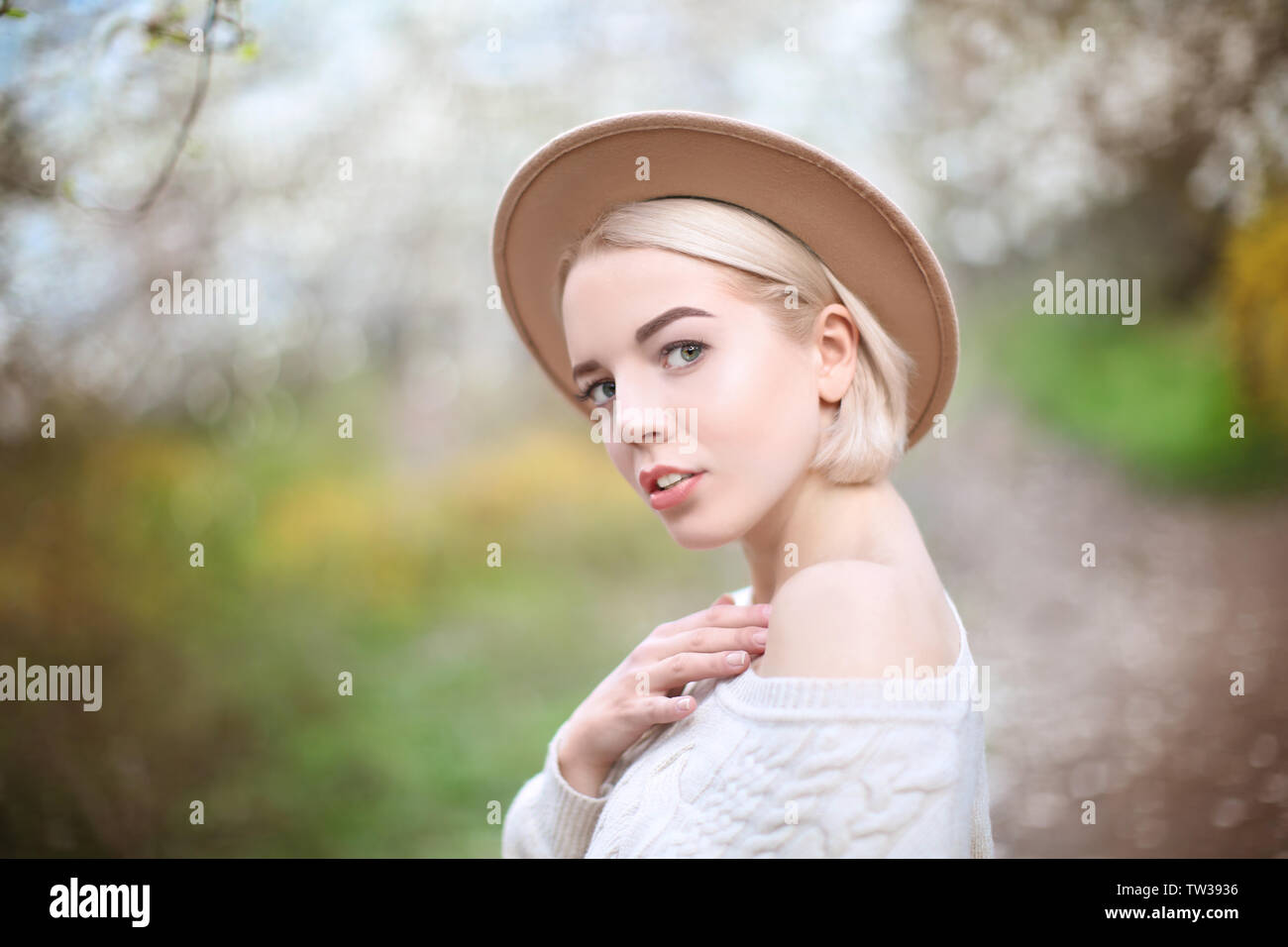 Young blonde girl in hat on blurred background Stock Photo