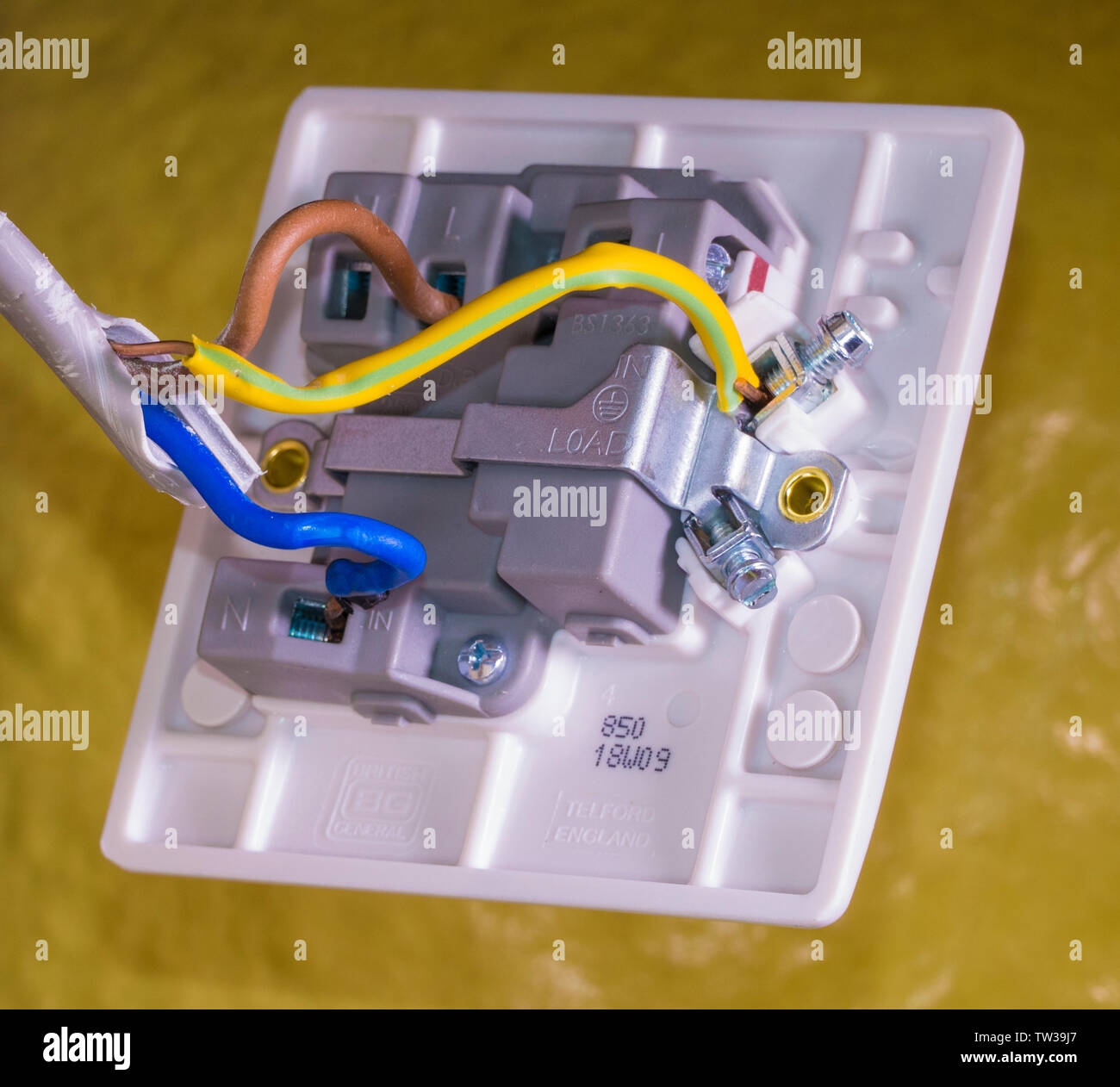 Closeup of connections for blue, brown and green/yellow wires, with a  screwdriver on a terminal, behind the on/off switch for a UK standard  appliance Stock Photo - Alamy