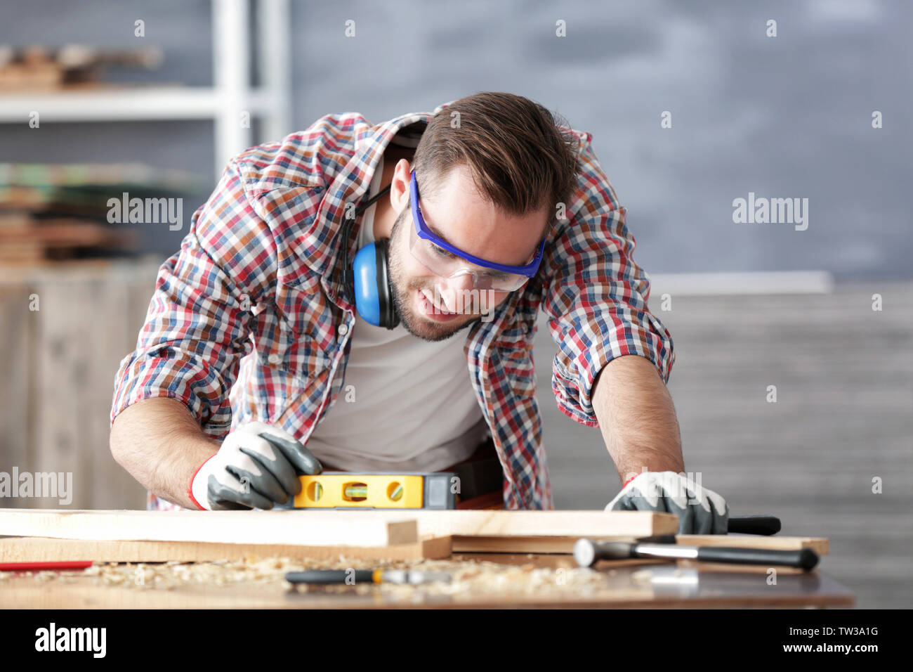 Young carpenter working with level in light shop Stock Photo