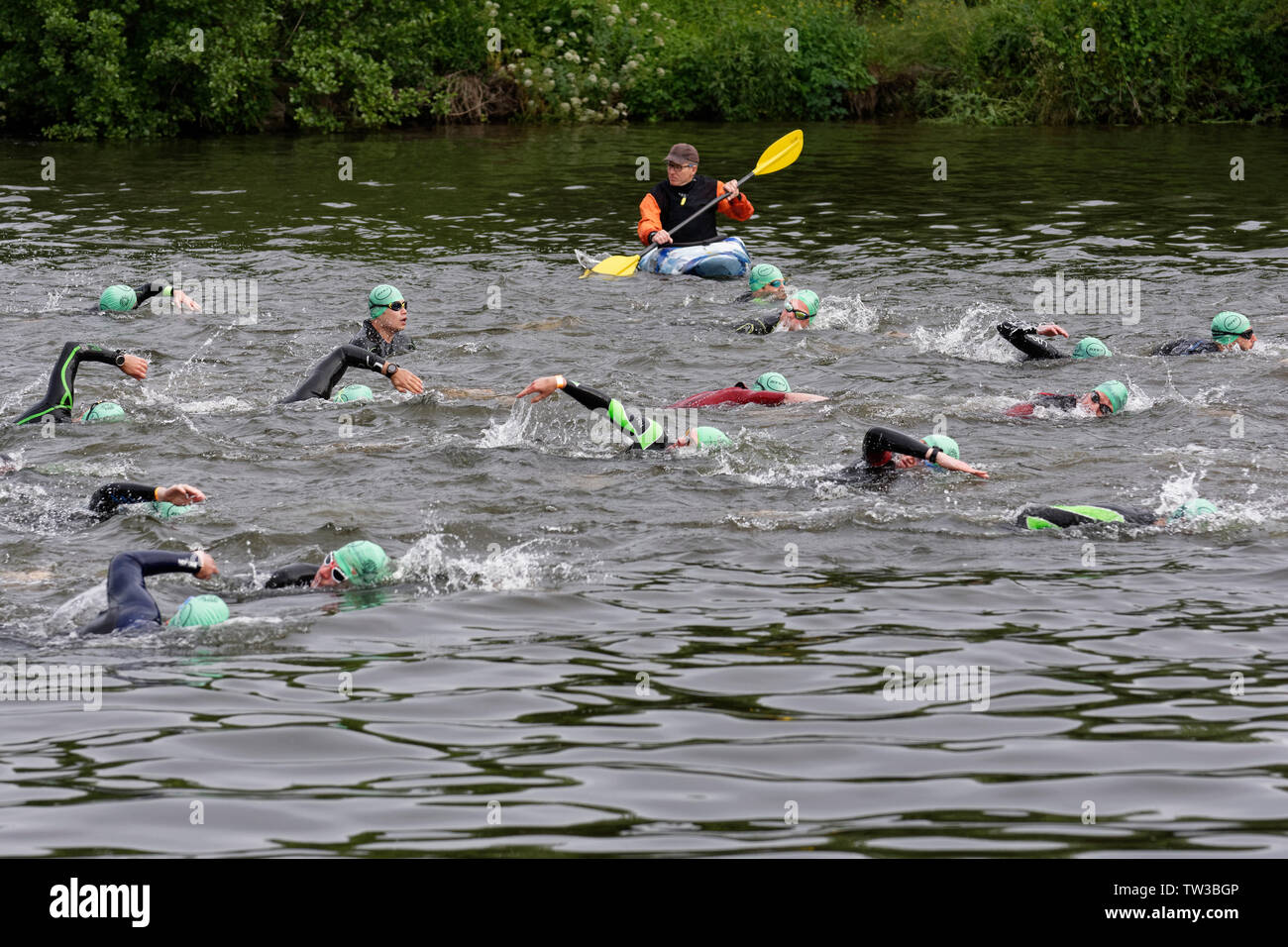 Swimmers in the Thames competing in the Royal Windsor Triathlon are overseen by the essential safety crew in their kyaks Stock Photo