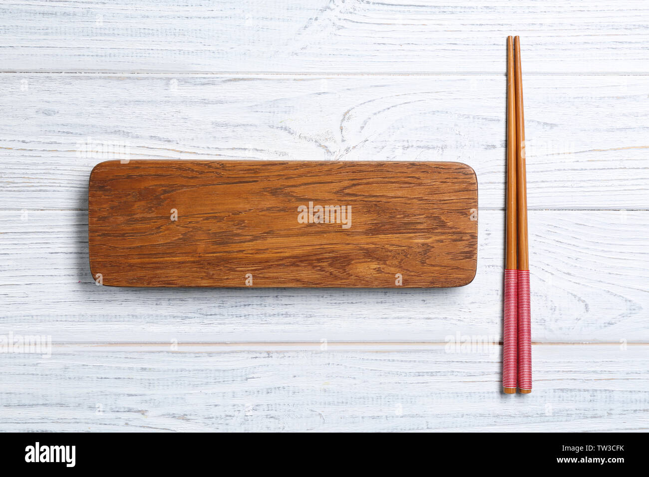 Rectangular wooden board and chopsticks on table Stock Photo