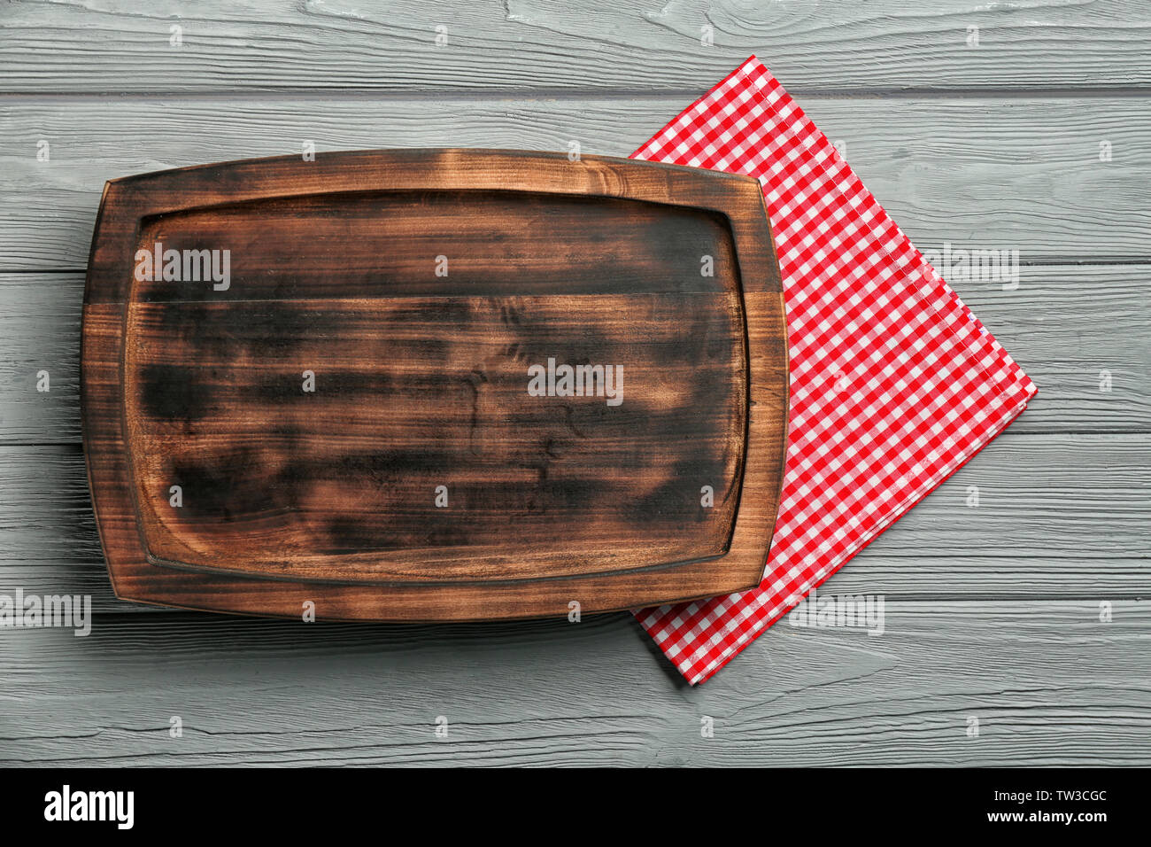 Empty rectangular wooden plate and napkin on table Stock Photo