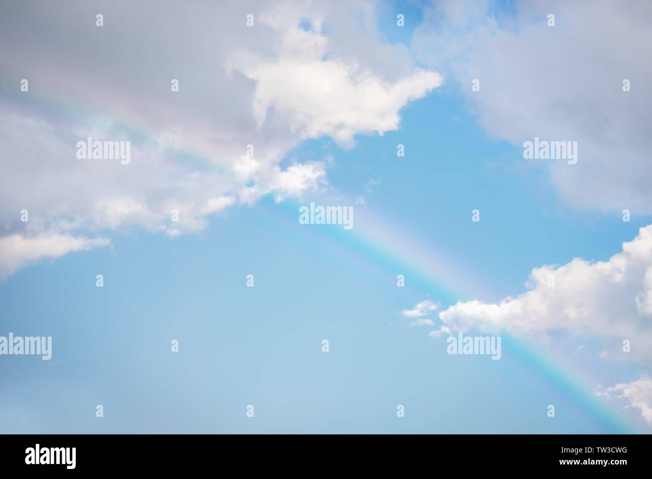 Rainbow in blue sky with white clouds hi-res stock photography and ...