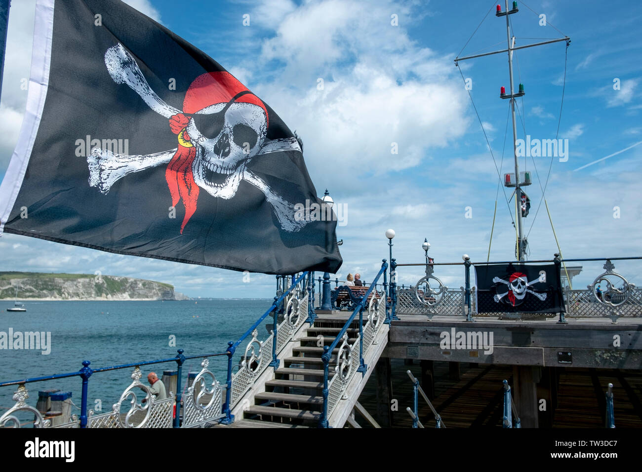 A skull and crossbones pirate flag flies on Swanage Pier, Dorset, UK Stock Photo