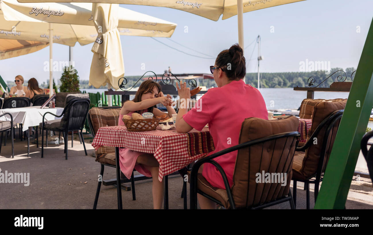 Belgrade, Serbia, June 16th 2019: Mother and daughter having breakfast at the Danube riverside restaurant terrace in Zemun Stock Photo