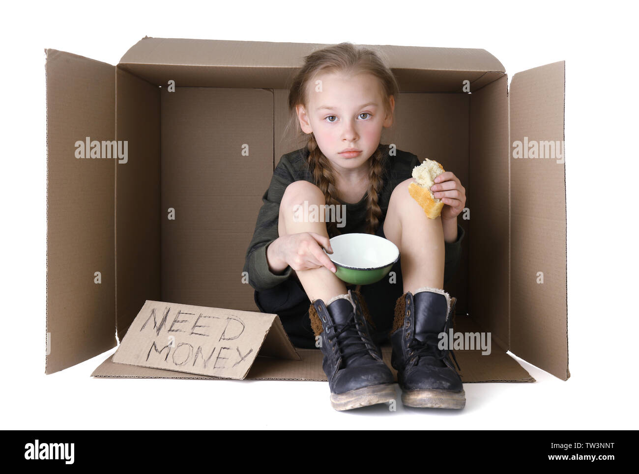 Poor little girl sitting in cardboard box and begging for money on white background Stock Photo