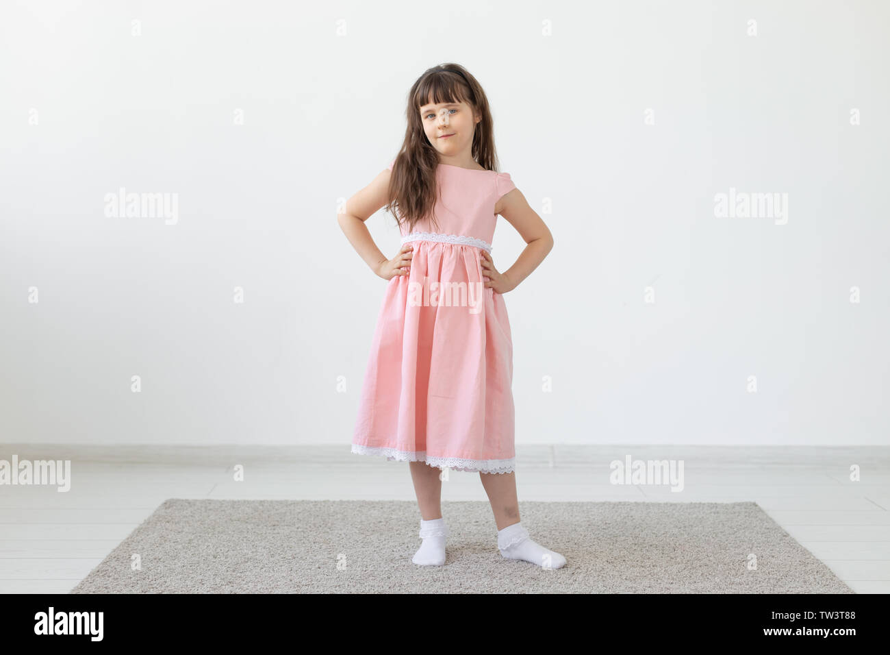 Little girl is a model, in a pink dress in studio Stock Photo - Alamy