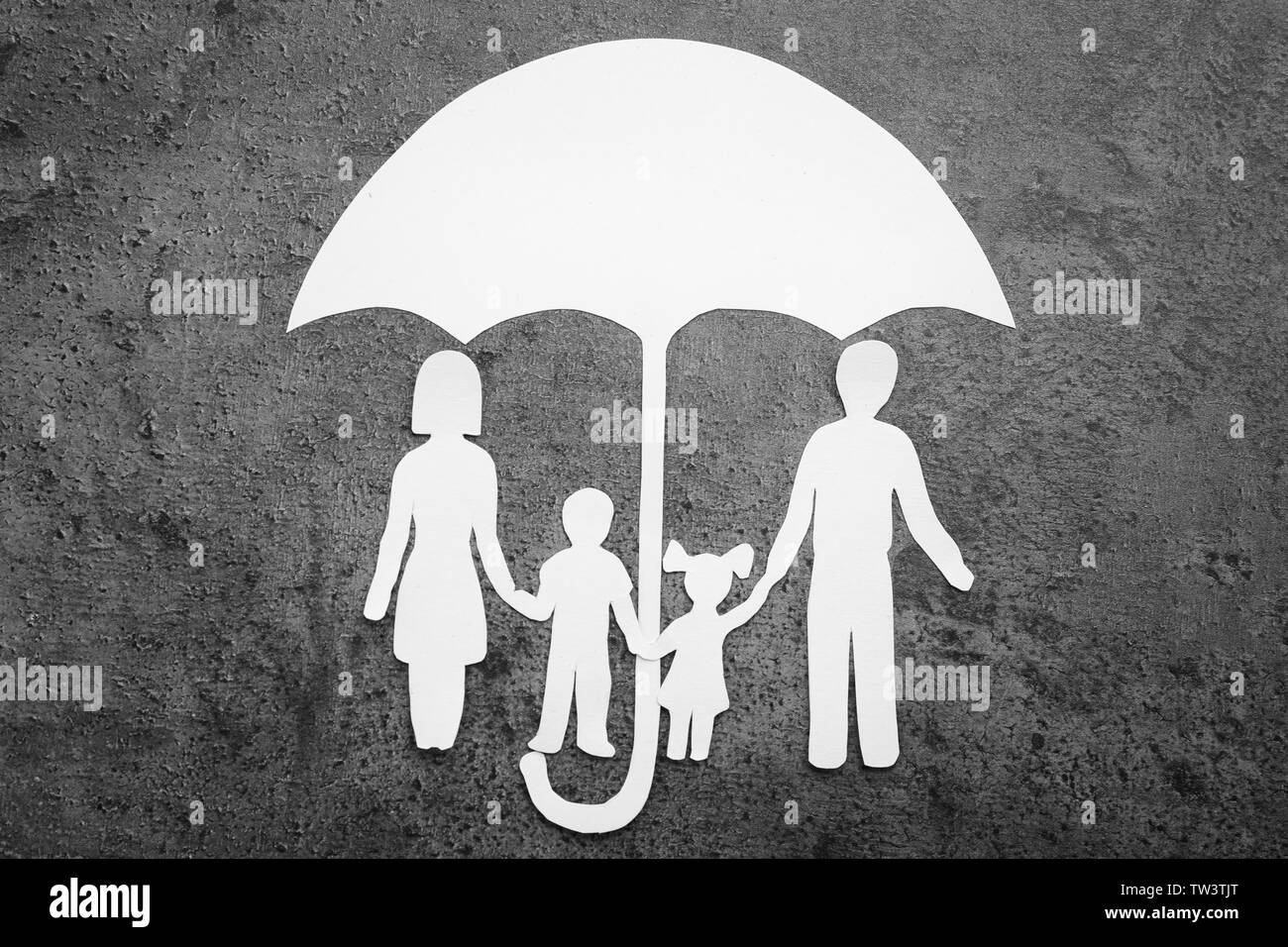 Paper silhouette of family under umbrella on grey background. Life insurance concept Stock Photo