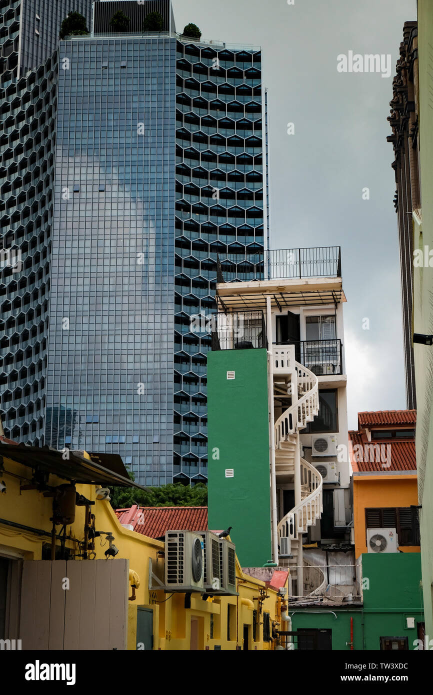Modern Duo towers in Singapore showing contrasting design overlooking the small residential traditional homes in the bugis haji lane  area Stock Photo