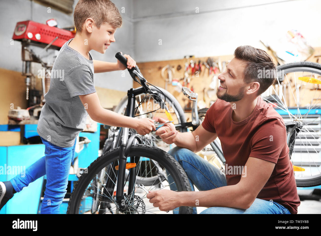 dad-and-son-fixing-bicycles-in-garage-TW3Y8B.jpg