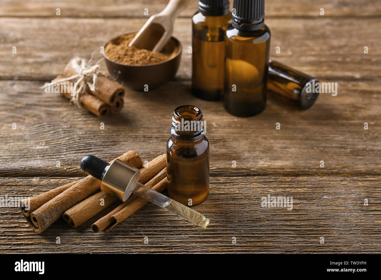 Composition with bottle of cinnamon oil on wooden background Stock Photo