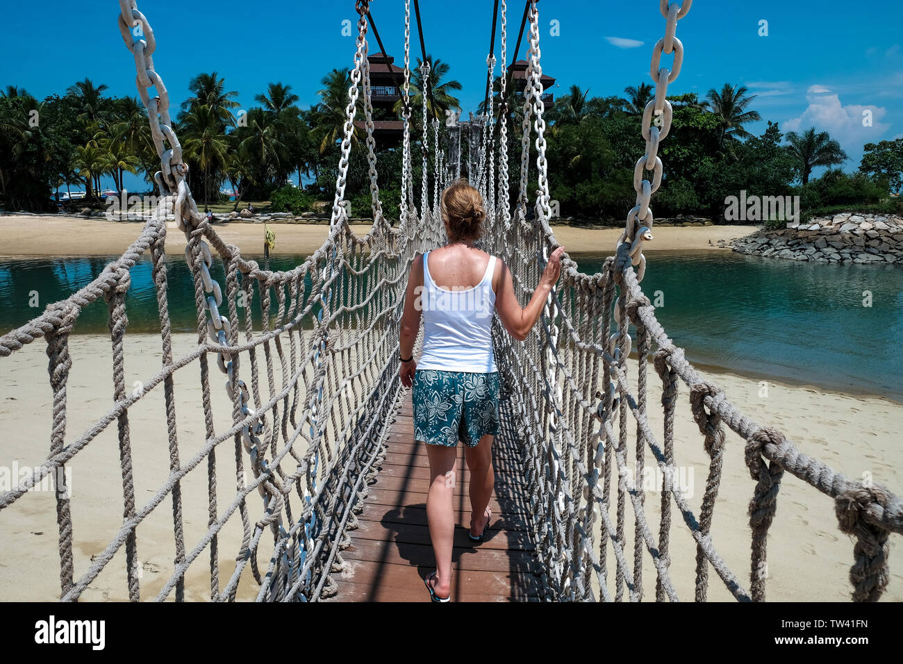 A single middle age female wearing shorts and vest top walks over the ...