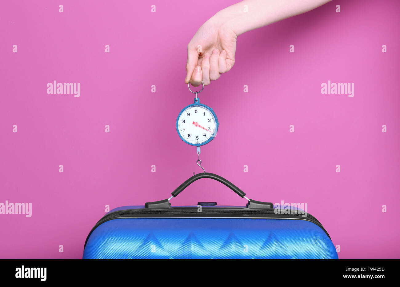 https://c8.alamy.com/comp/TW425D/woman-weighting-heavy-luggage-on-color-background-TW425D.jpg