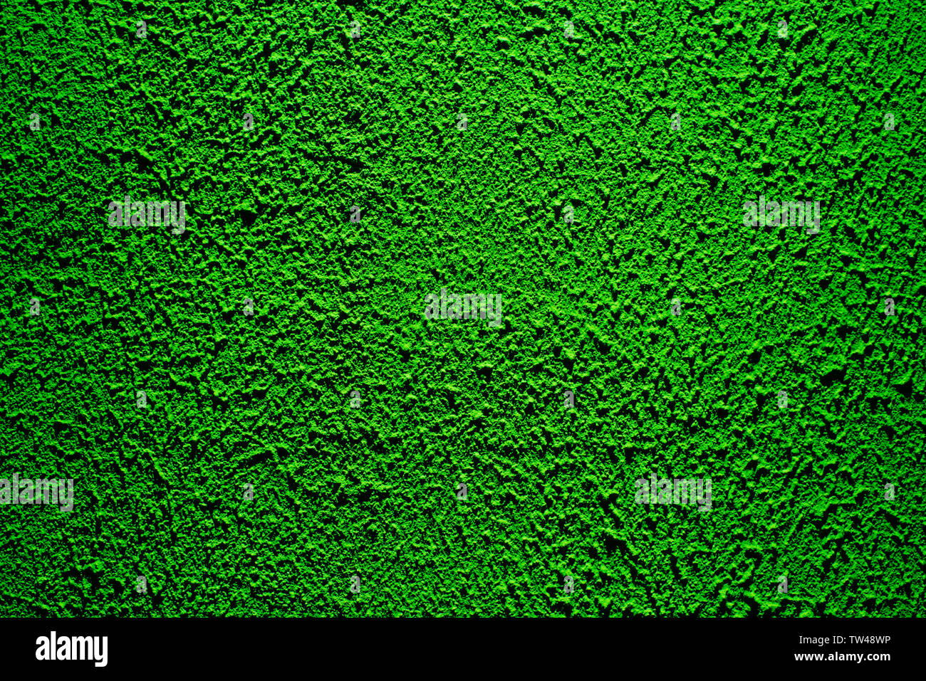 Brightly lit surface covered with bright green plaster. Trend color Stock Photo